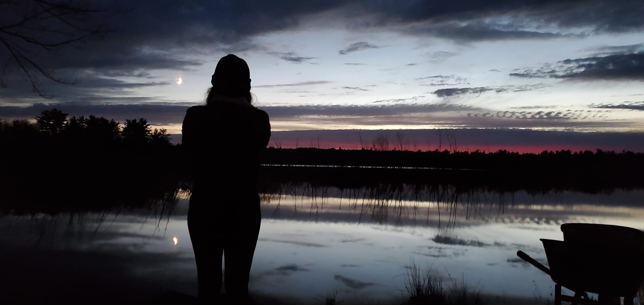 ty45 A woman standing in front of the water at dusk.