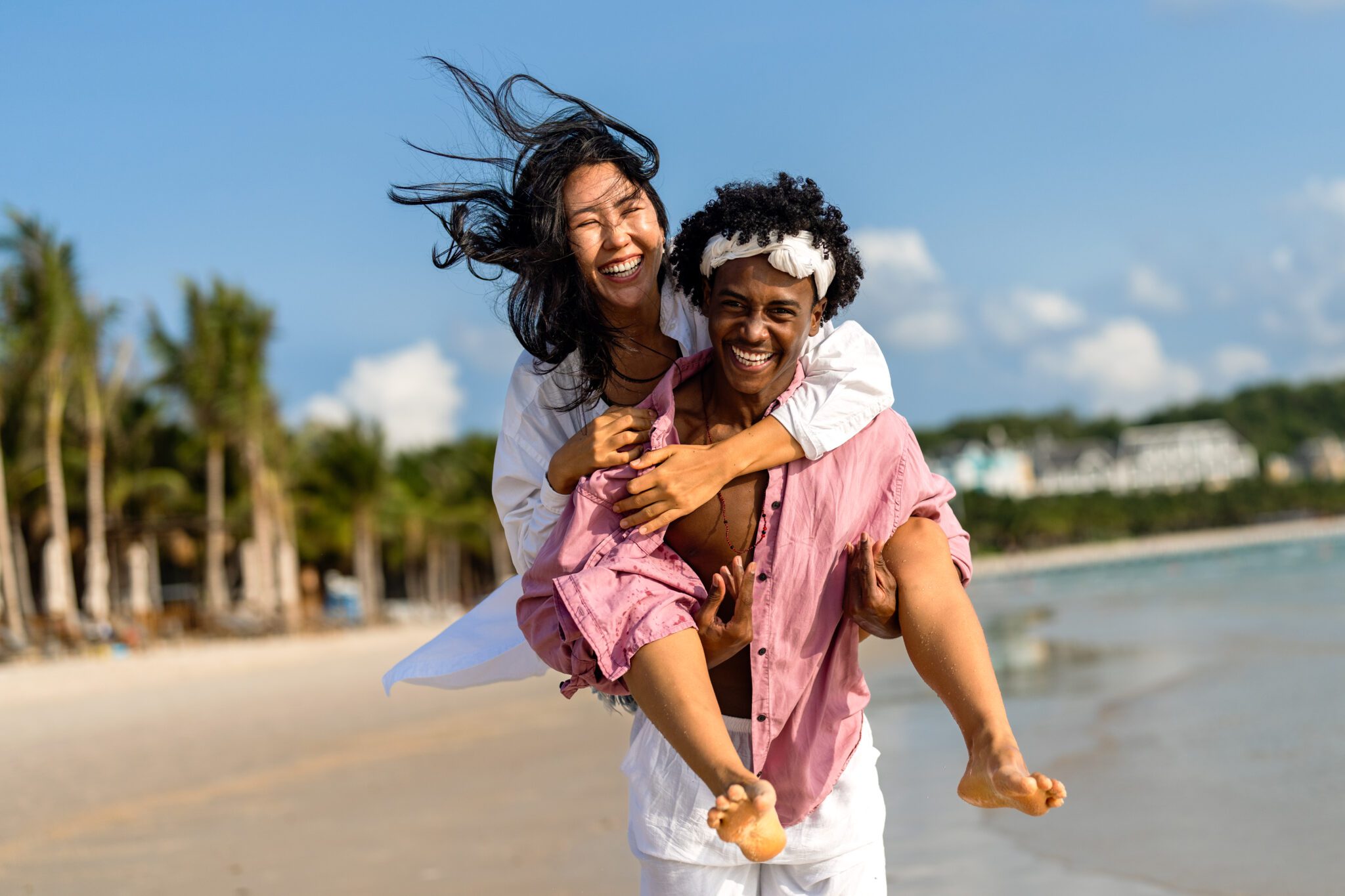 Interracial couple enjoying a romantic beach getaway, embracing love, laughter, and togetherness A man and woman are walking on the beach.