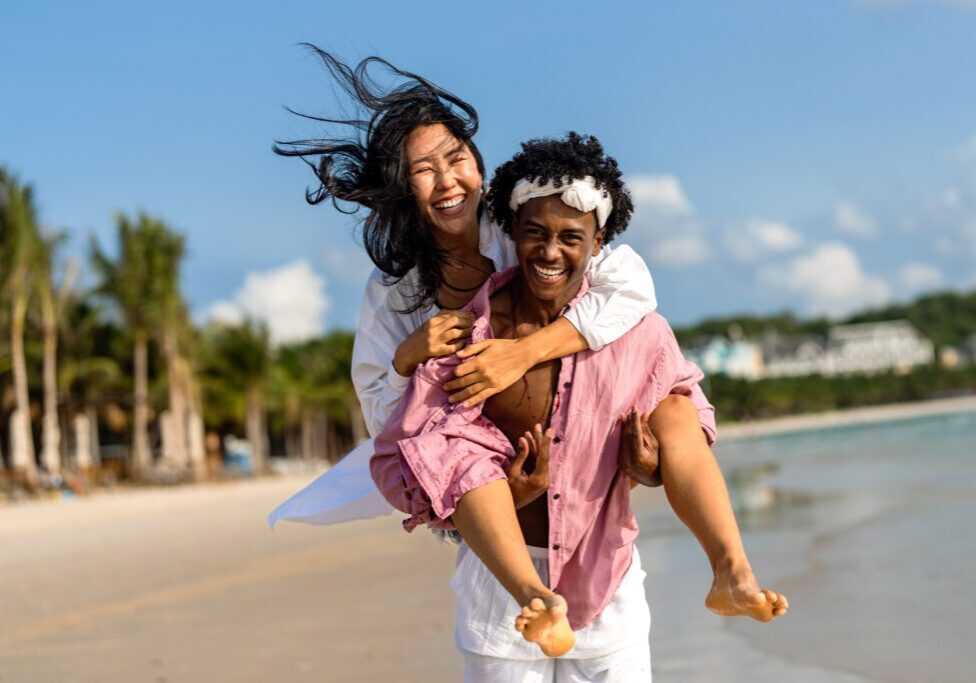A man and woman are walking on the beach.