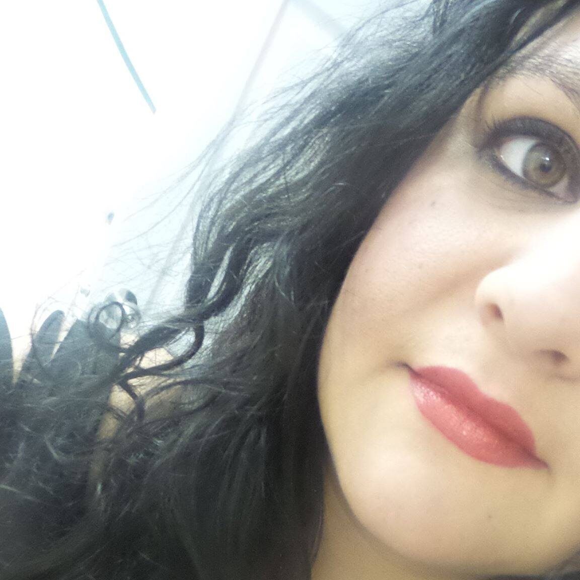 me A woman with long black hair and red lipstick.